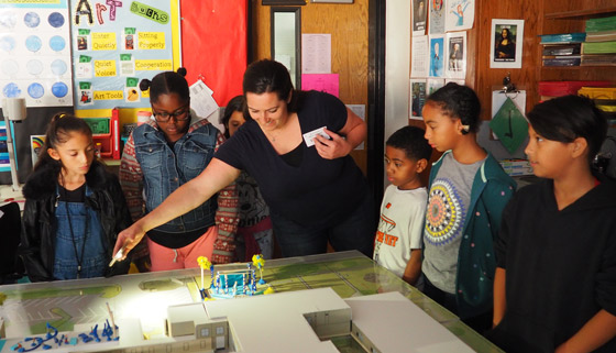 Page volunteer Lorrie Tumlinson explains to Blackshear Elementary students how the path of the sun could influence the design of the school's proposed outdoor performance venue. - Page