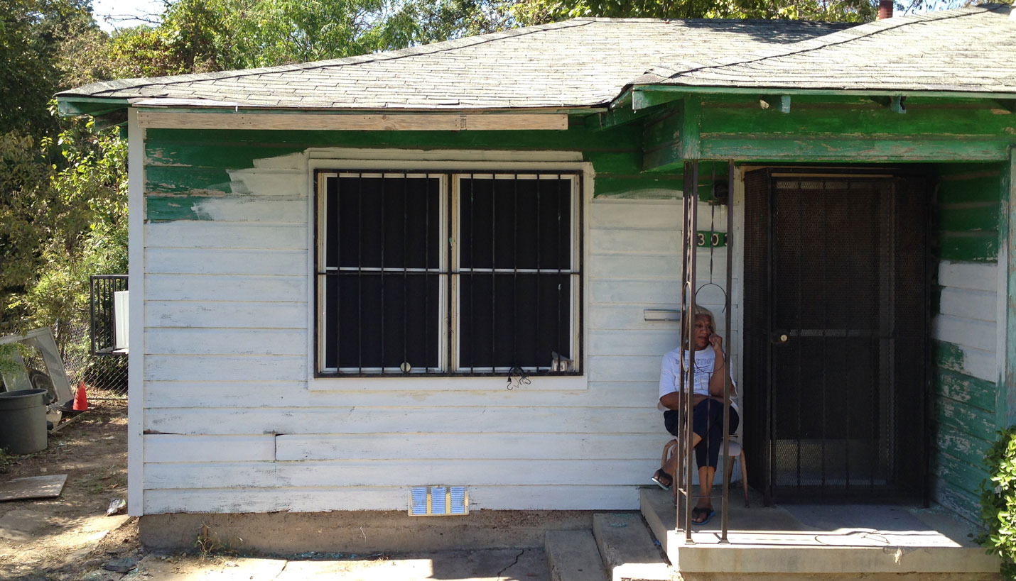 Ms. Sanders sitting on her porch before the final work is completed on her house. -